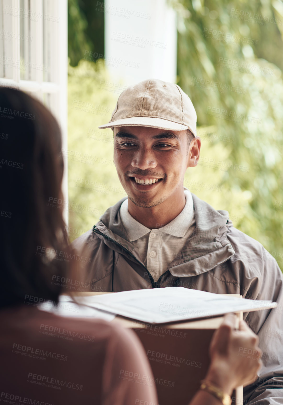 Buy stock photo Shot of a young man delivering a package to a customer at home