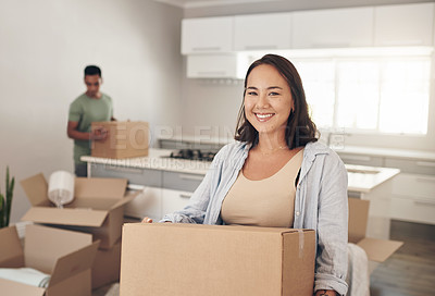 Buy stock photo Shot of a woman holding a box while moving into her new home with her partner