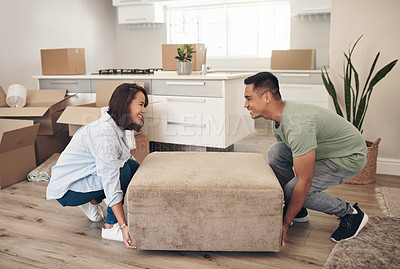 Buy stock photo Shot of a couple moving furniture in their new home