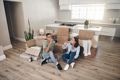 Buy stock photo Shot of a young couple drinking wine in their new home