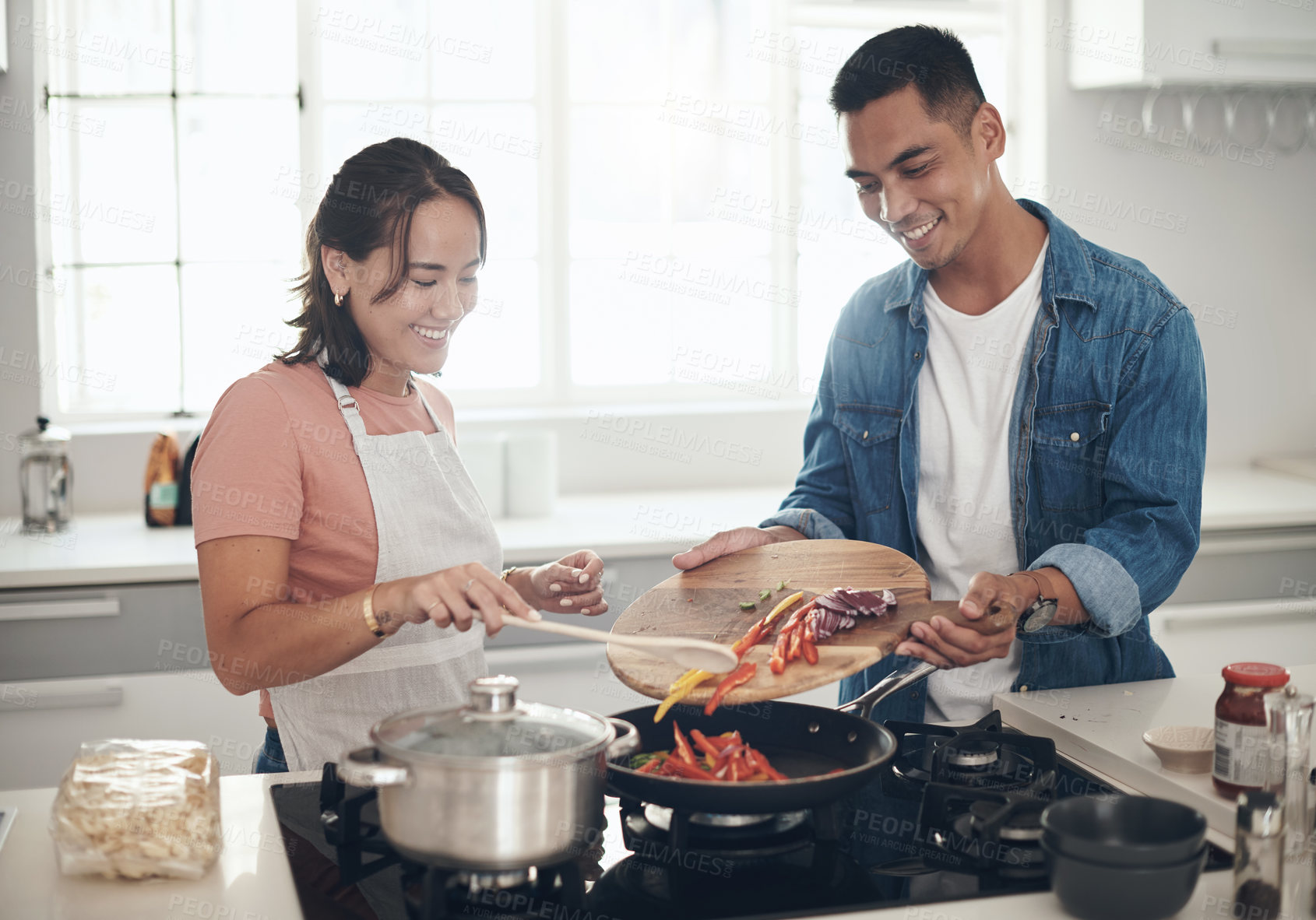 Buy stock photo Shot of a young couple cooking together at home