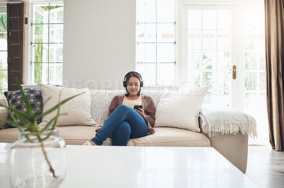 Buy stock photo Woman, headphones and phone for social media on couch, internet and music to relax in home. Female person, online and streaming movie or gossip article and song, reading and ebook or app for chat