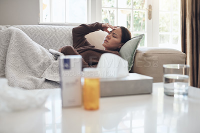 Buy stock photo Tired woman, sick and headache with medication on sofa for flu, cold or sinus in living room at home. Young female person with illness, fever or influenza in fatigue or rest on couch from paracetamol