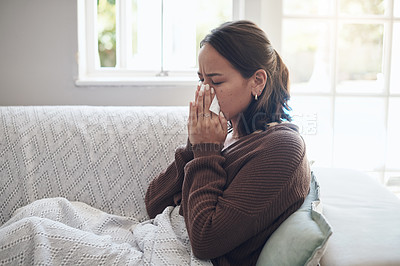 Buy stock photo Sick woman, tissue and blowing nose with sinus, flu or illness on living room sofa at home. Young female person with paper for sneeze, fever or influenza from infection on lounge couch at house
