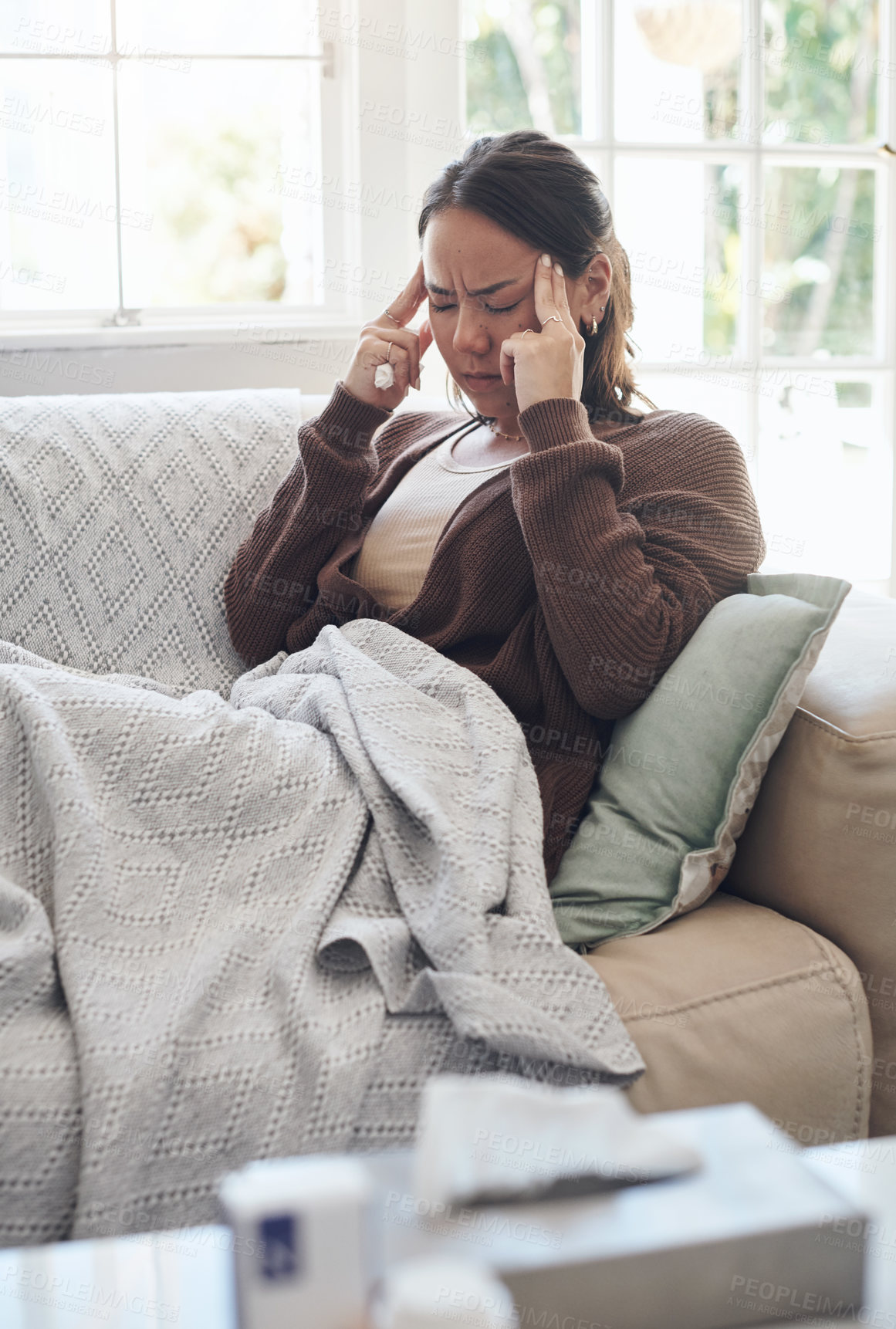 Buy stock photo Sick woman, tissue and headache with flu, sinus or pain from illness on living room sofa at home. Young female person with migraine from high fever, influenza or infection on lounge couch at house