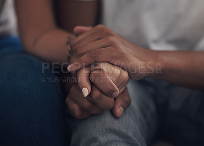 Buy stock photo Cropped shot of an unrecognizable couple sitting inside together and holding hands