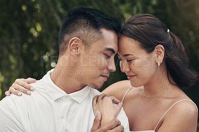 Buy stock photo Shot of a happy young couple standing outside together and sharing a romantic moment