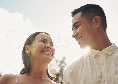 Buy stock photo Shot of a happy young couple standing outside together during the day