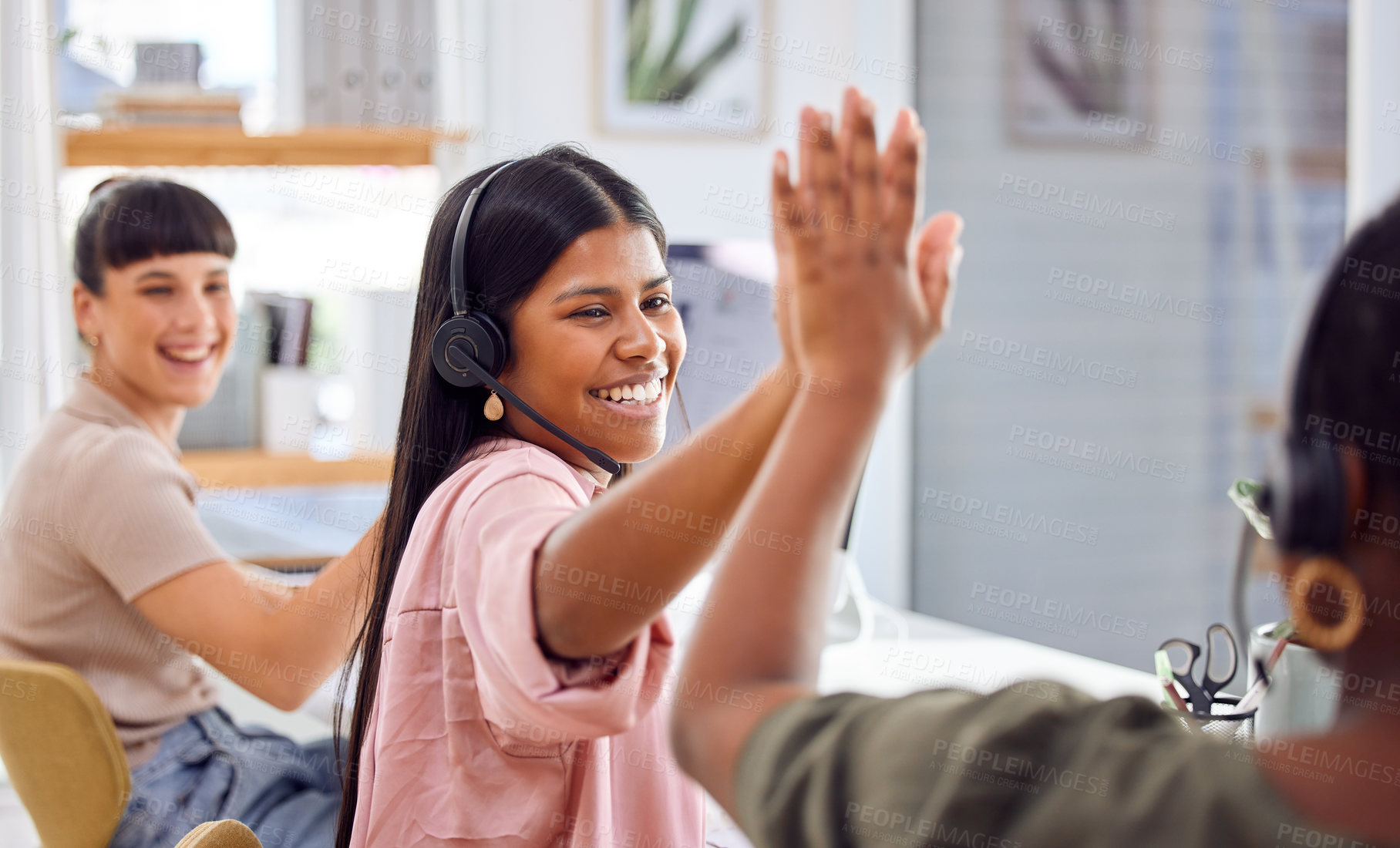 Buy stock photo Shot of two businesspeople sharing a high-five while working in a call centre