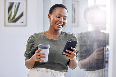 Buy stock photo Shot of a businesswoman drinking coffee and using her cellphone while standing in an office