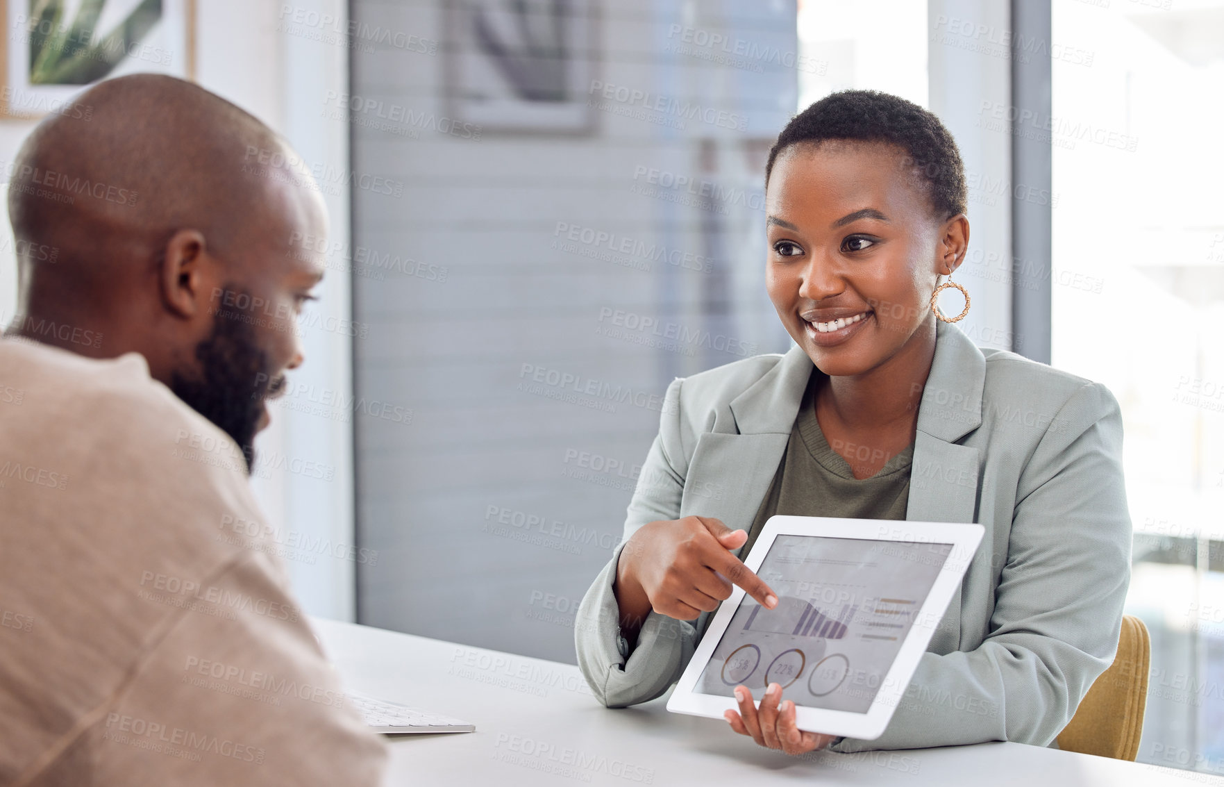 Buy stock photo Shot of a businesswoman showing her colleague graphs on a digital tablet