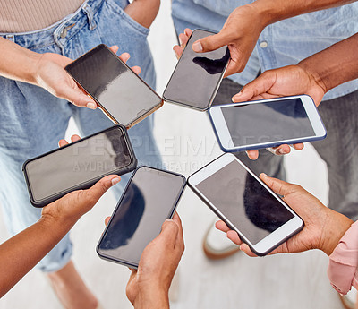 Buy stock photo Shot of a group of unrecognizable people standing in a circle and using digital devices in an office