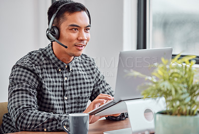 Buy stock photo Cropped shot of a handsome young male call center agent working on his laptop