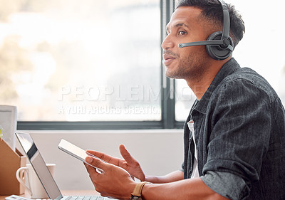 Buy stock photo Cropped shot of a handsome young male call center agent looking thoughtful while working on his tablet