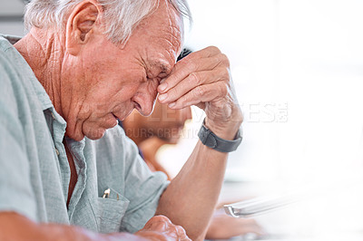 Buy stock photo Shot of a mature businessman looking stressed in an office