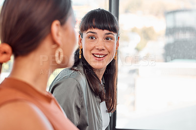Buy stock photo Shot of two young businesspeople talking in an office