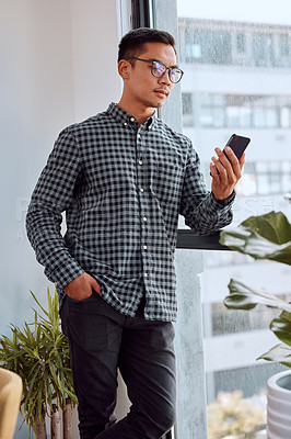 Buy stock photo Man, phone and window in office for reading notification, email and deal from contact at startup. Business person, smartphone and check for texting, chat and mobile app at media agency in Shanghai