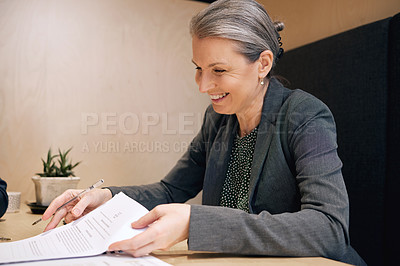 Buy stock photo Cropped shot of an attractive mature female financial advisor going over some paperwork in her office