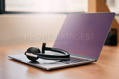 Buy stock photo Still life shot of a wireless headset and a laptop on a desk in a call center