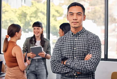 Buy stock photo Portrait of a young businessman at the office standing in front of his colleagues having a meeting in the background