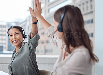 Buy stock photo Shot of two businesswoman working in a call center high fiving each other in success