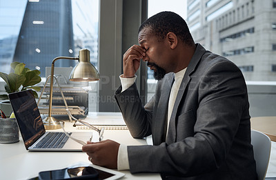 Buy stock photo Shot of a young businessman experiencing a headache at work