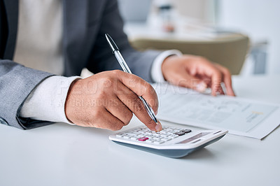 Buy stock photo Closeup shot of an unrecognisable businessman using a calculator while going through paperwork in an office