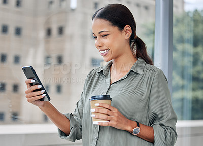 Buy stock photo Shot of a young businesswoman using a cellphone while drinking coffee at a window in an office