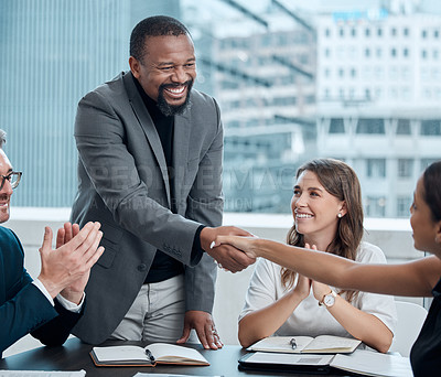 Buy stock photo Cropped shot of a handsome businessman shaking hands with a female colleague during a meeting in the boardroom