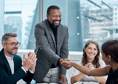 Buy stock photo Cropped shot of a handsome businessman shaking hands with a female colleague during a meeting in the boardroom