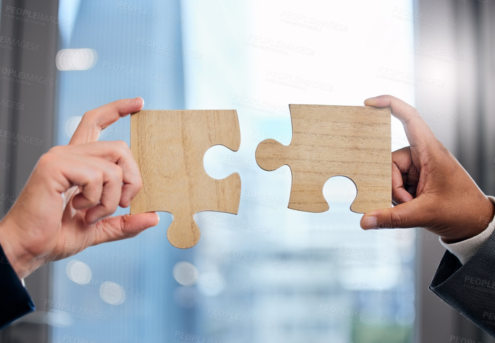Buy stock photo Cropped shot of two businesspeople completing a puzzle together in a modern office