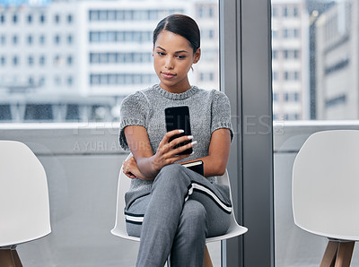Buy stock photo Shot of a young businesswoman using a phone in a waiting room