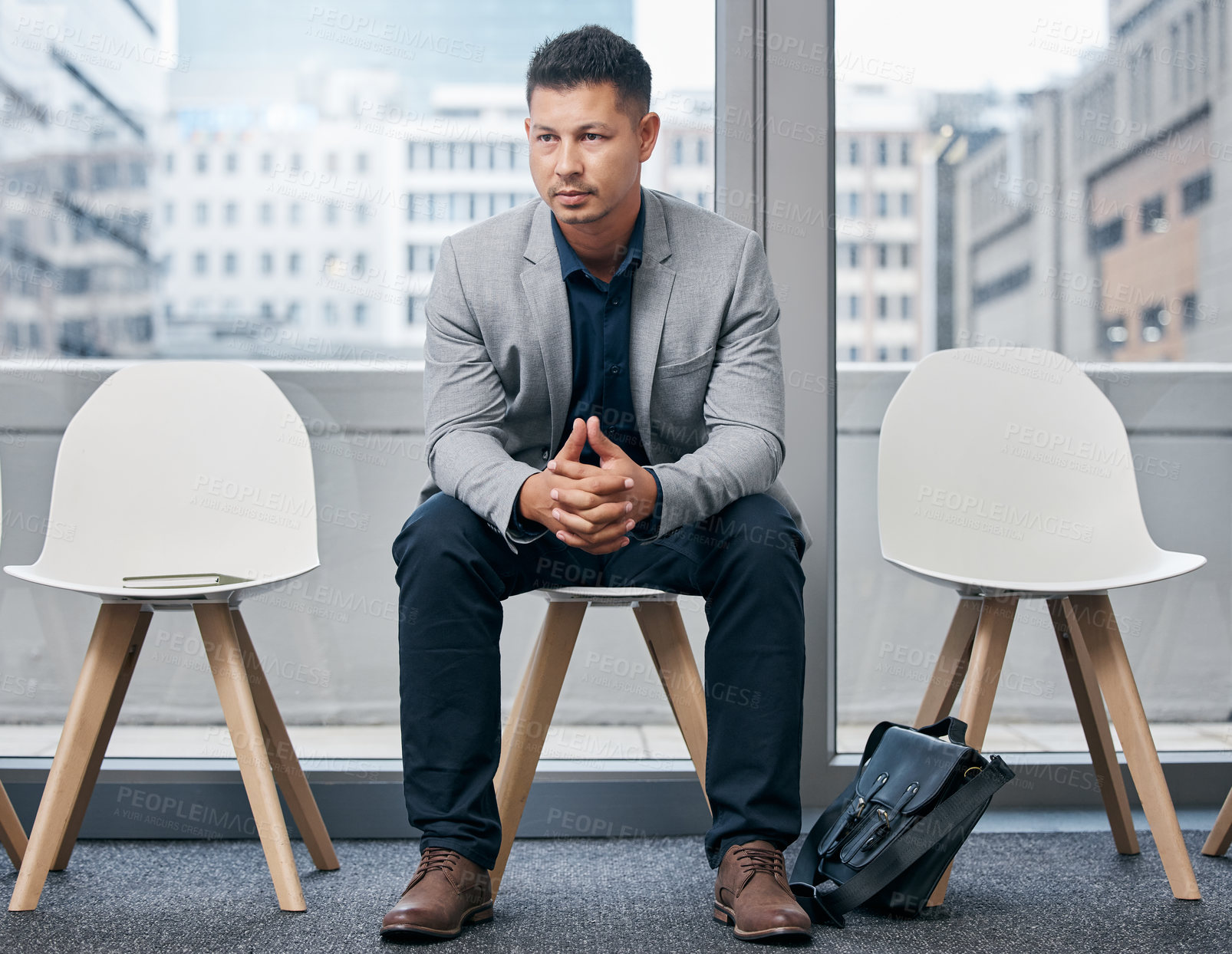 Buy stock photo Shot of a young businessman sitting in a waiting room