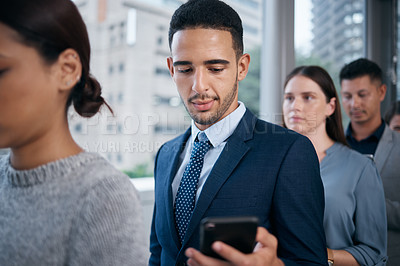 Buy stock photo Shot of a young businessman using a phone in a waiting room