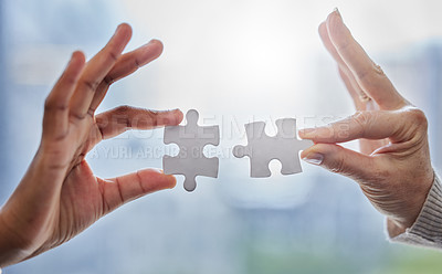 Buy stock photo Shot of two people joining puzzle pieces together