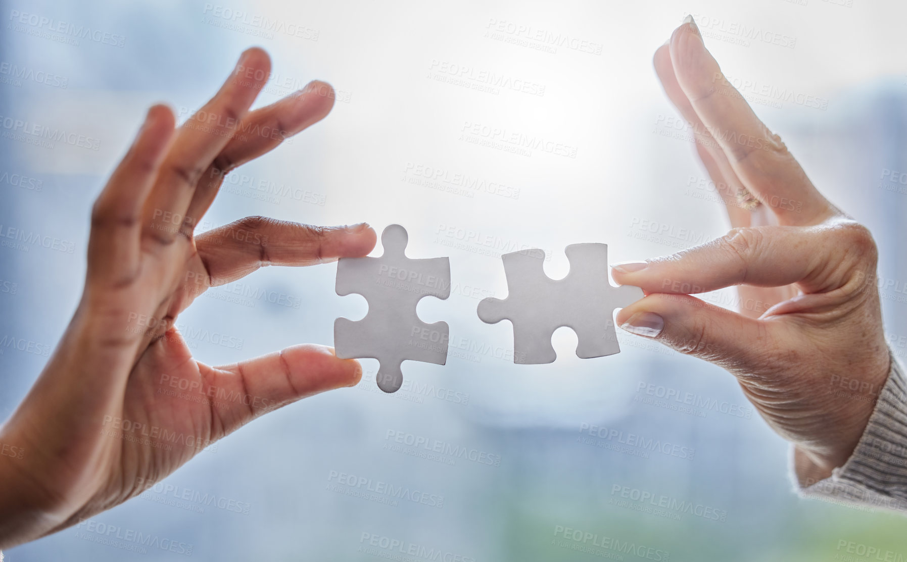 Buy stock photo Shot of two people joining puzzle pieces together