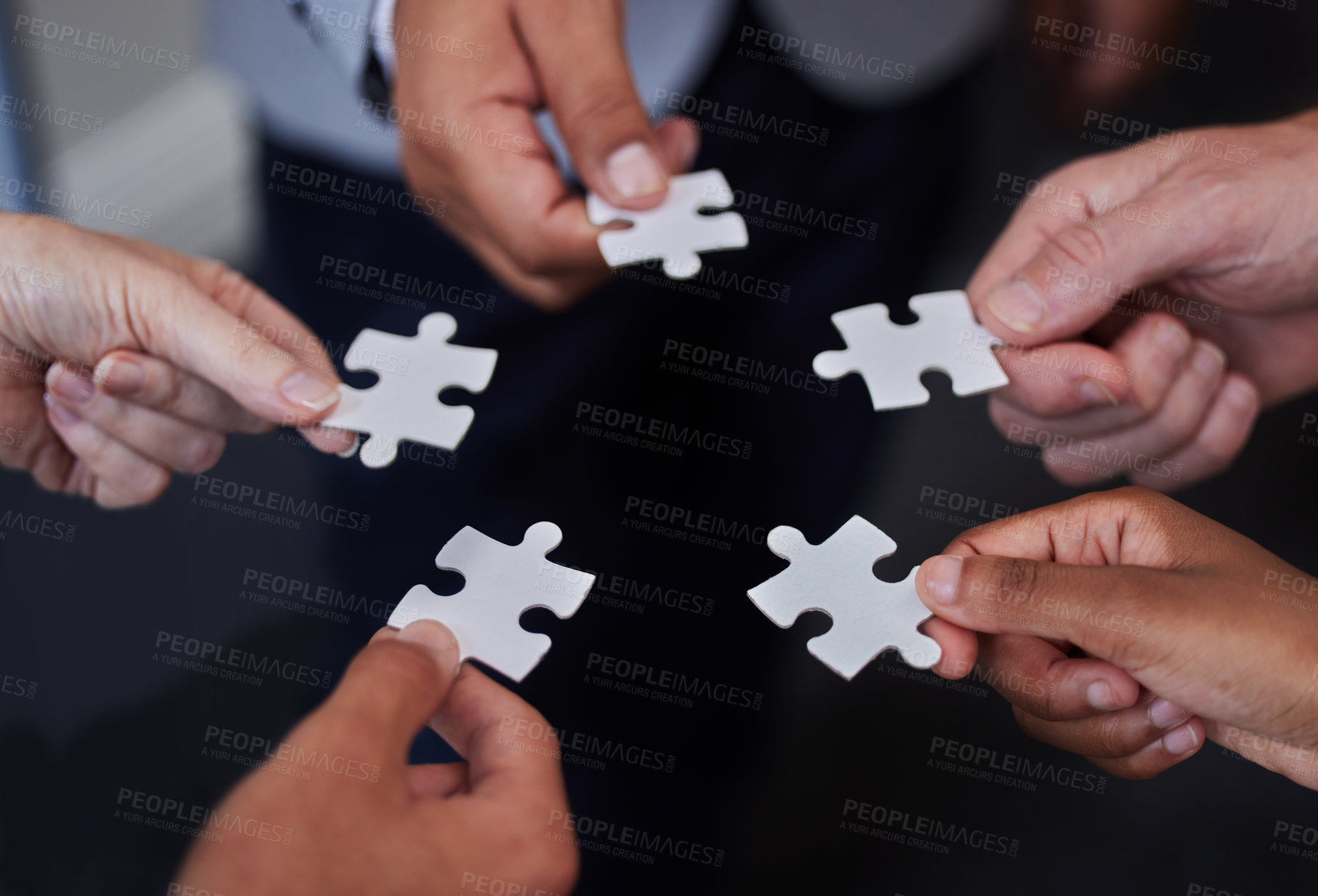 Buy stock photo Shot of a group of businesspeople putting together puzzle pieces