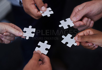Buy stock photo Shot of a group of businesspeople putting together puzzle pieces