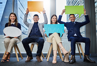 Buy stock photo Shot of a group of young businesspeople holding speech bubbles while waiting in line