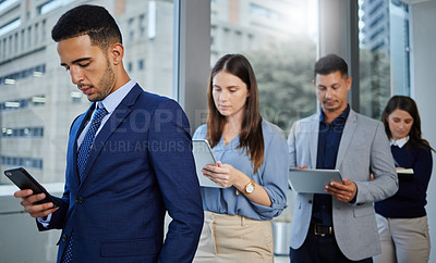 Buy stock photo Shot of a group of businesspeople using digital devices while waiting in line