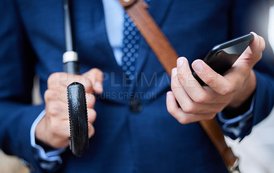 Buy stock photo Cropped shot of an unrecognizable businessman on checking his phone while on his morning commute into work