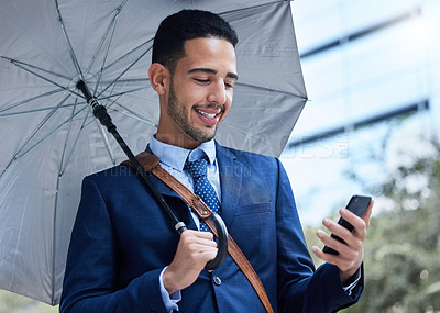 Buy stock photo Cropped portrait of a handsome young businessman with an umbrella on his morning commute into work