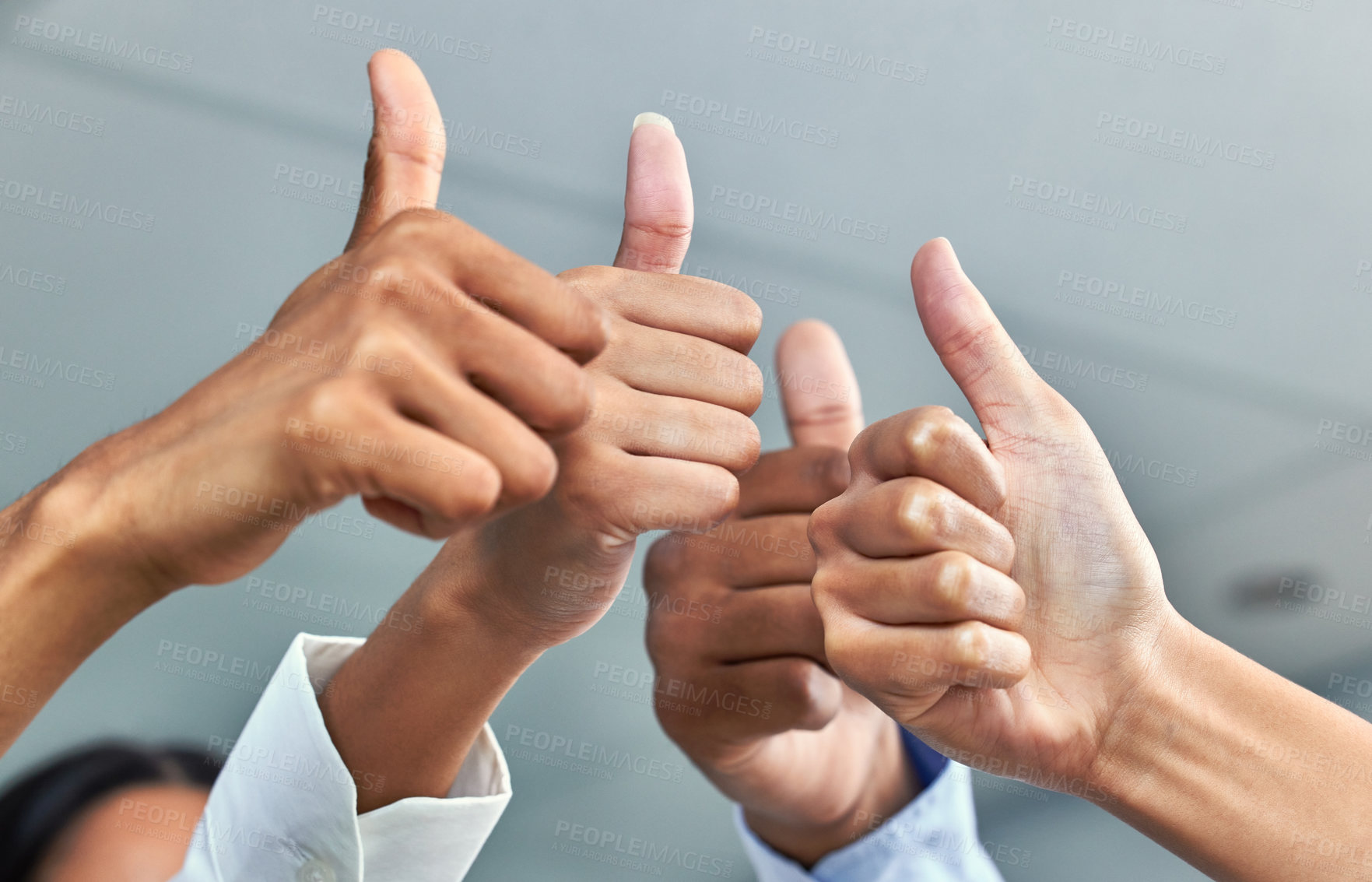 Buy stock photo Cropped shot of a group of unrecognizable businesspeople showing thumbs up while standing in their office