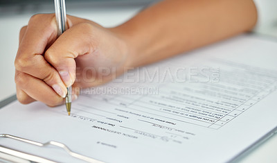 Buy stock photo Cropped shot of an unrecognizable businesswoman filling out a questionnaire while sitting in her office