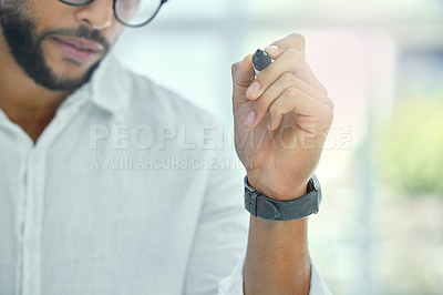 Buy stock photo Cropped shot of an unrecognizable businessman working on a glass wipe board in his office