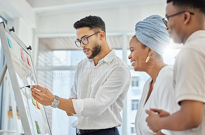 Buy stock photo Cropped shot of a group of diverse young businesspeople working on a whiteboard in the boardroom