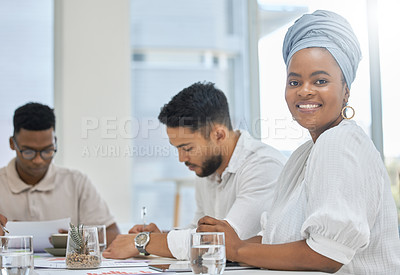 Buy stock photo Cropped portrait of an attractive young businesswoman gathered with her colleagues around a table in the boardroom