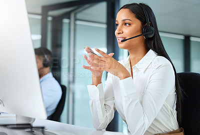 Buy stock photo Shot of a young call centre agent sitting at her desk and explaining to a client while wearing a headset