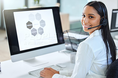 Buy stock photo Shot of an attractive young call centre agent sitting in the office and wearing a headset while using her computer