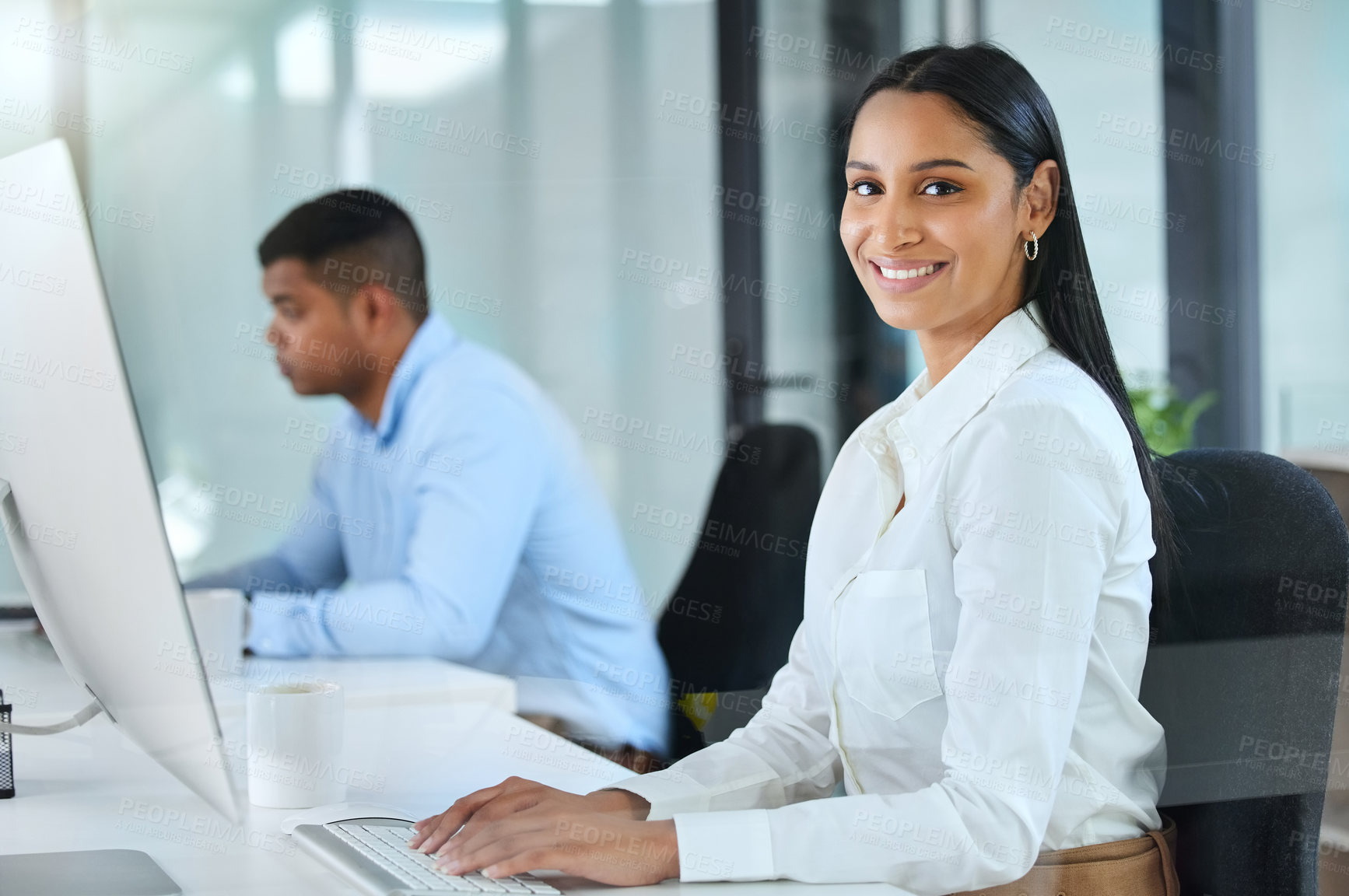 Buy stock photo Shot of a young call centre agent sitting in the office with a colleague and wearing a headset